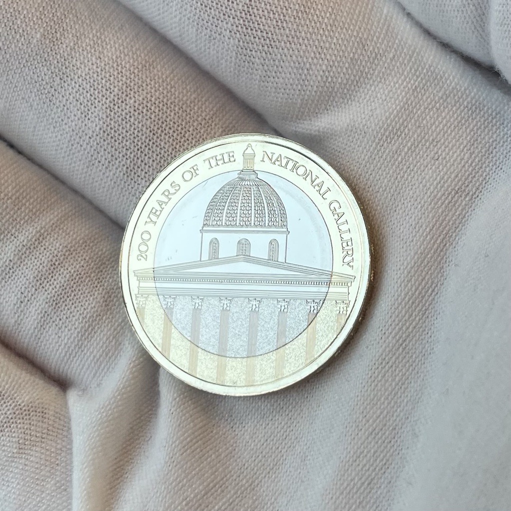 National Gallery £2 coin in a gloved hand